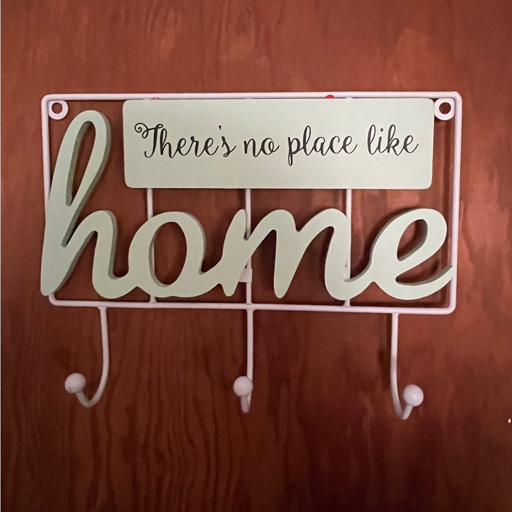 Wooden Cost hanger with 3- hooks with a sign saying (there's no place like home)